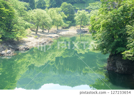 Waga River with beautiful fresh green leaves reflecting in the water, Iwate Prefecture Waga River with beautiful fresh green leaves reflecting in the water, Iwate Prefecture 127233654