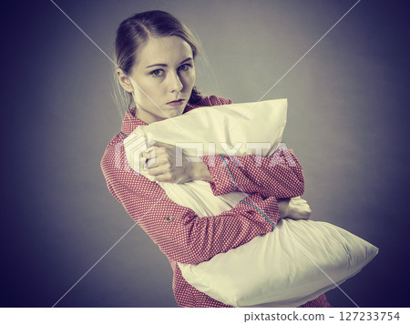 Sad depressed girl in bed gripping pillow Sad depressed girl in bed gripping pillow 127233754