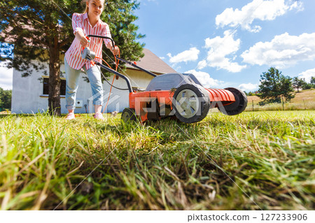 Person mowing green grass Person mowing green grass 127233906