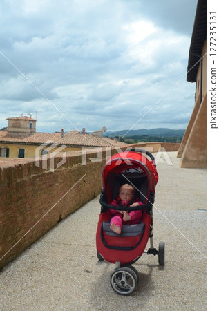 Baby in Red Stroller on Cobblestone Path 127235131