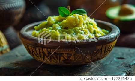 Ugandan matoke, a comforting dish of mashed green bananas served in a traditional African bowl. Staple food of Uganda. 127235426