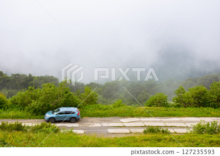perechyn, ukraine - 22 ju2 2019: 4wd car on a countryside mountain road. family suv for weekend on the hillside. mountain landscape of carpathian alps on a foggy morning in summer. vacation memories perechyn, ukraine - 22 ju2 2019: 4wd car on a countryside mountain road. family suv for weekend on the hillside. mountain landscape of carpathian alps on a foggy morning in summer. vacation memories 127235593
