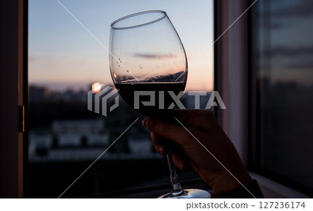 hand holding a glass of red wine 127236174
