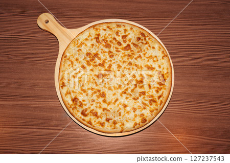 cheese pizza on wooden background. Delicious freshly prepared meal, perfect for menus, restaurants, or food delivery concepts. 127237543