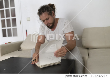 Focused artist drawing and sketching at home studio 127237713