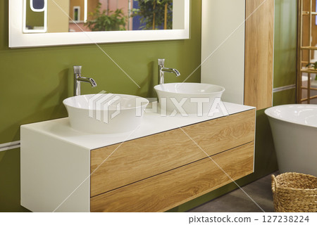 Modern bathroom with ceramic bathtub, double sinks and mirror above it, there are no people 127238224