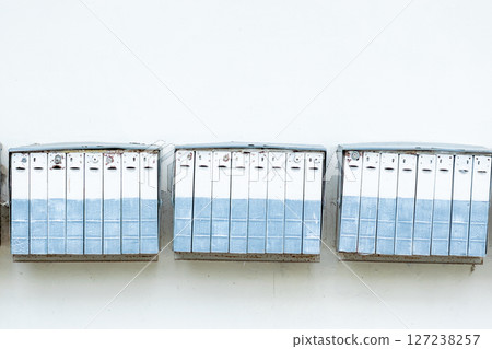 Very old mail boxes hanging on white wall 127238257