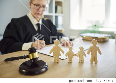 Judge woman in professional outfit black robe writing reviewing family jurisprudence documents  127238305