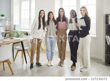 Portrait of confident women group looking cheerful at camera and smiling standing in a row Portrait of confident women group looking cheerful at camera and smiling standing in a row 127238372