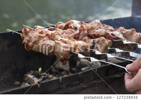 closeup of some meat skewers being grilled in a barbecue 127238938