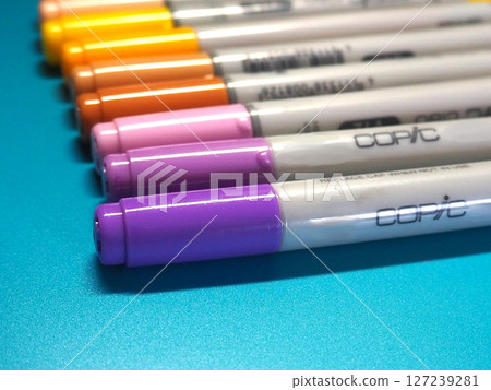 Copic markers lined up side by side, photographed diagonally 127239281