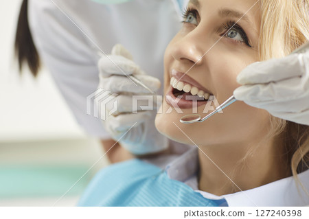 Dentist Examining Woman Patient In Clinic With Instrument Dentist Examining Woman Patient In Clinic With Instrument 127240398