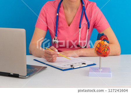 Doctor consult patient on laptop with anatomical model of human heart Cardiologist supports the heart Online doctor appointment. 127241604