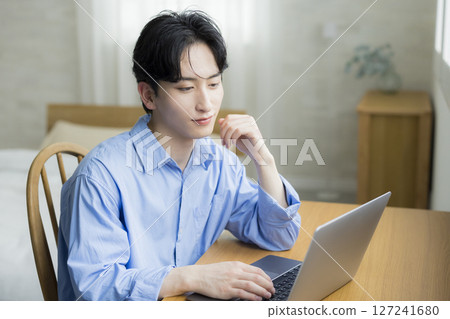 A young man using a computer 127241680