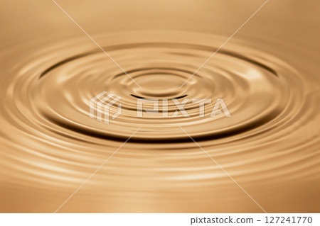 Water droplet dripping into pool creating ripples 127241770