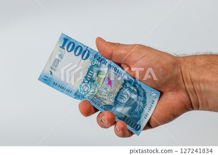 Person holding a blue banknote in their hand during daylight 127241834
