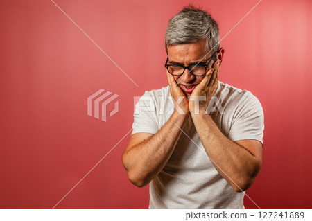Man expressing concern against a red background Man expressing concern against a red background 127241889