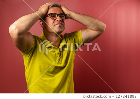 Man expresses frustration against a bright red background Man expresses frustration against a bright red background 127241892