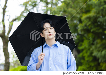 Young man holding a parasol 127241988