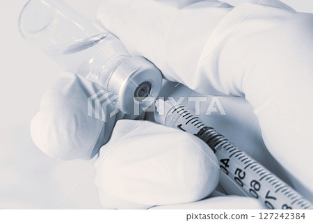 Doctor takes vaccine with syringe from ampule 127242384