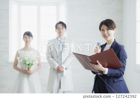 Bride and groom and host 127242392
