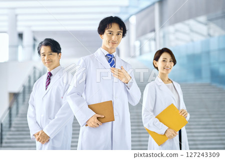 Three men and women wearing white coats Medical image 127243309
