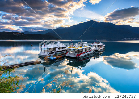 日月潭風景—朝霧碼頭,美麗的湖面景觀映照出奇幻的日出天空。亞洲台灣南投著名的旅遊景點。 日月潭風景—朝霧碼頭,美麗的湖面景觀映照出奇幻的日出天空。亞洲台灣南投著名的旅遊景點。 127243738