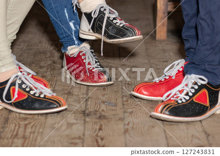 People legs with bowling shoes standing on old wooden floor 127243831