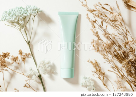 Mock up of light green bottle without labeling. Blank container cream or facial cleanser top view on plain white color with dry flowers. Minimal Organic cosmetic advertising. Eco bio ingredients 127243890