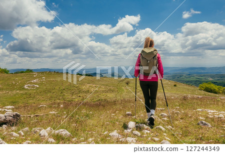 Woman Hiker with Backpack Walking in Mountains Woman Hiker with Backpack Walking in Mountains 127244349