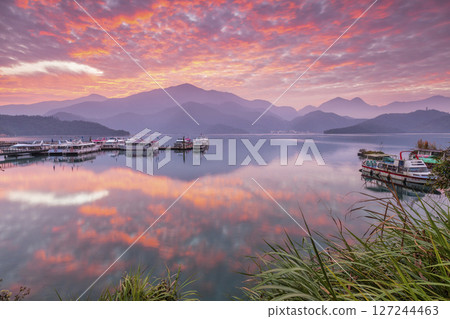 Sun Moon Lake scenery - beautiful lake view reflecting the fantastic sunrise sky. Famous tourist attraction in Nantou County, Taiwan, Asia. Sun Moon Lake scenery - beautiful lake view reflecting the fantastic sunrise sky. Famous tourist attraction in Nantou County, Taiwan, Asia. 127244463