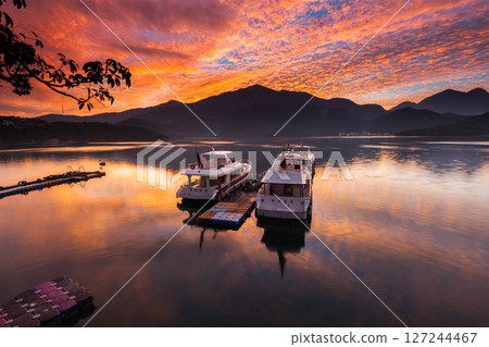 Sun Moon Lake scenery - beautiful lake view reflecting the fantastic sunrise sky. Famous tourist attraction in Nantou County, Taiwan, Asia. Sun Moon Lake scenery - beautiful lake view reflecting the fantastic sunrise sky. Famous tourist attraction in Nantou County, Taiwan, Asia. 127244467