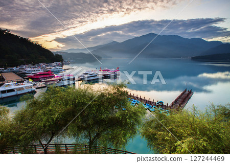 日月潭風景—美麗的湖面景觀映照出奇幻的日出天空。亞洲台灣南投縣著名的旅遊景點。 127244469