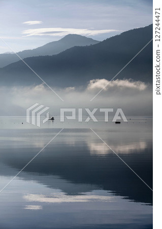 日月潭風景—美麗的湖面景觀映照出奇幻的日出天空。亞洲台灣南投縣著名的旅遊景點。 127244471