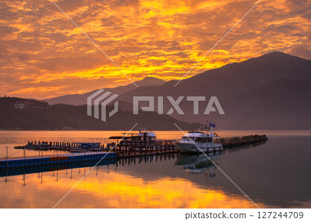 日月潭風景—美麗的湖面景觀映照出奇幻的日出天空。亞洲台灣南投縣著名的旅遊景點。 127244709