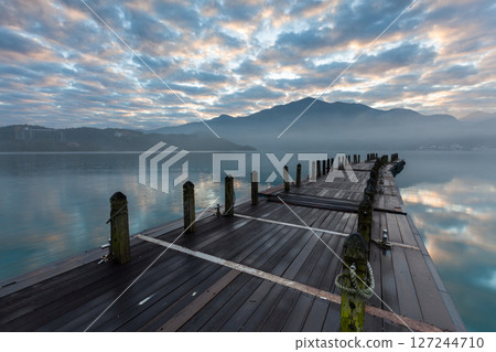 日月潭風景—美麗的湖面景觀映照出奇幻的日出天空。亞洲台灣南投縣著名的旅遊景點。 日月潭風景—美麗的湖面景觀映照出奇幻的日出天空。亞洲台灣南投縣著名的旅遊景點。 127244710
