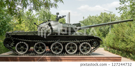 Soviet T-62 tank on a pedestal in a green park, a monument honoring military history 127244732