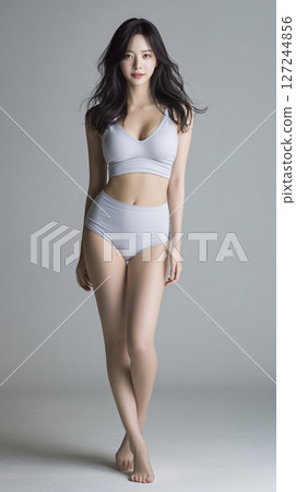 Woman is wearing a grey bikini top and bikini bottoms 127244856