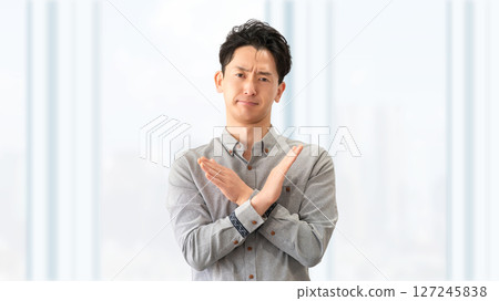 Male businessman making a cross pose with his hands 127245838