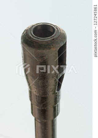 Close-up of an artillery muzzle brake, isolated against the sky, highlighting the metal texture 127245861