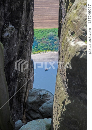 View through rocks to boat on river Elbe in Germany View through rocks to boat on river Elbe in Germany 127246067
