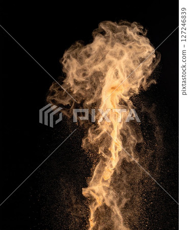 Golden Powder Explosion Against Black Background 127246839