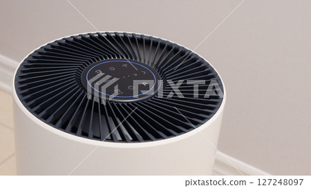 Close up view of Air Purifier with Black Fan. Black Round Electronic Device with Buttons and Bright Lights on White Background 127248097