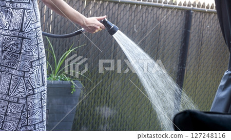 Watering Splendor A Woman s Touch, Gardens Thrive, Nature s Embrace in the Backyard. 127248116