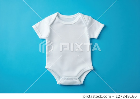 White Onesie. Baby clothes on blue pastel background. Fashion newborn clothes. Flat lay, top view. Baby kids clothing set. Smooth Infant bodysuit made from organic eco friendly cotton. Gender neutral 127249160