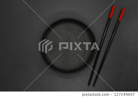 Cast iron bowl and chinese sticks Cast iron bowl and chinese sticks 127249847