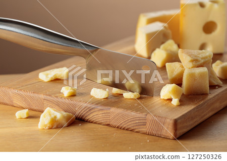 Parmesan cheese and knife on a cutting board. Parmesan cheese and knife on a cutting board. 127250326