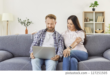 Family Couple Enjoying Online Entertainment Together On Couch At Home Family Couple Enjoying Online Entertainment Together On Couch At Home 127251505