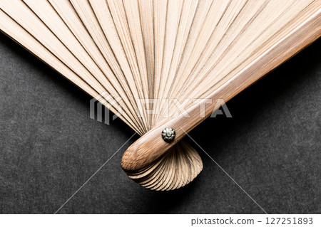 Background of Evenly Expanded Wooden Fan Flasks on Black Surface 127251893