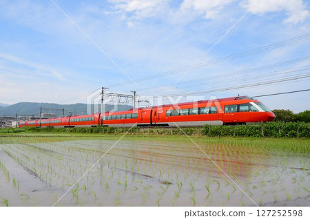 Odakyu 70000 series GSE traveling through a rice paddy area 127252598